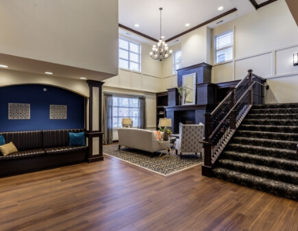 Community lobby area with large staircase and seating nearby